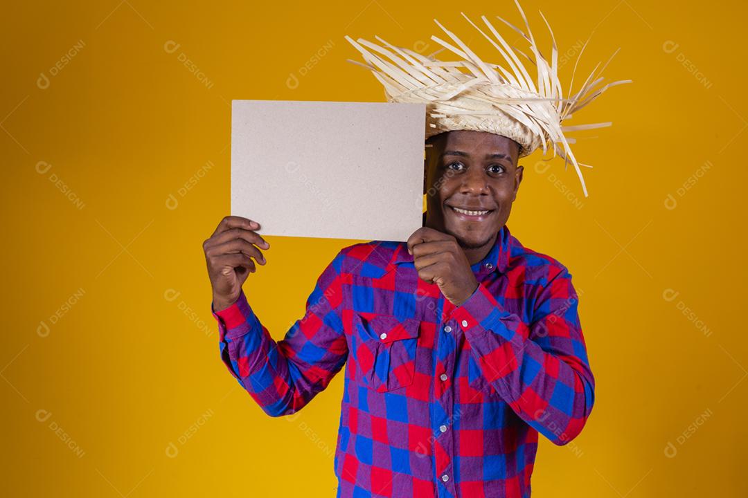 Homem afro brasileiro vestindo roupas típicas para a Festa Junina