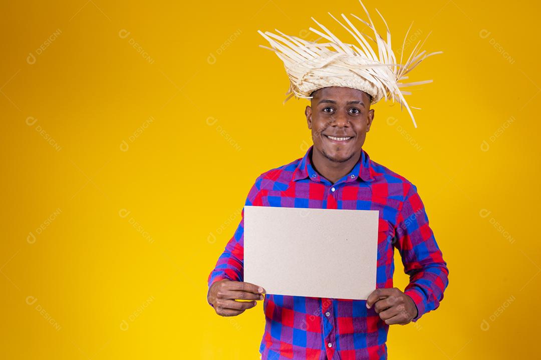 Homem afro brasileiro vestindo roupas típicas para a Festa Junina