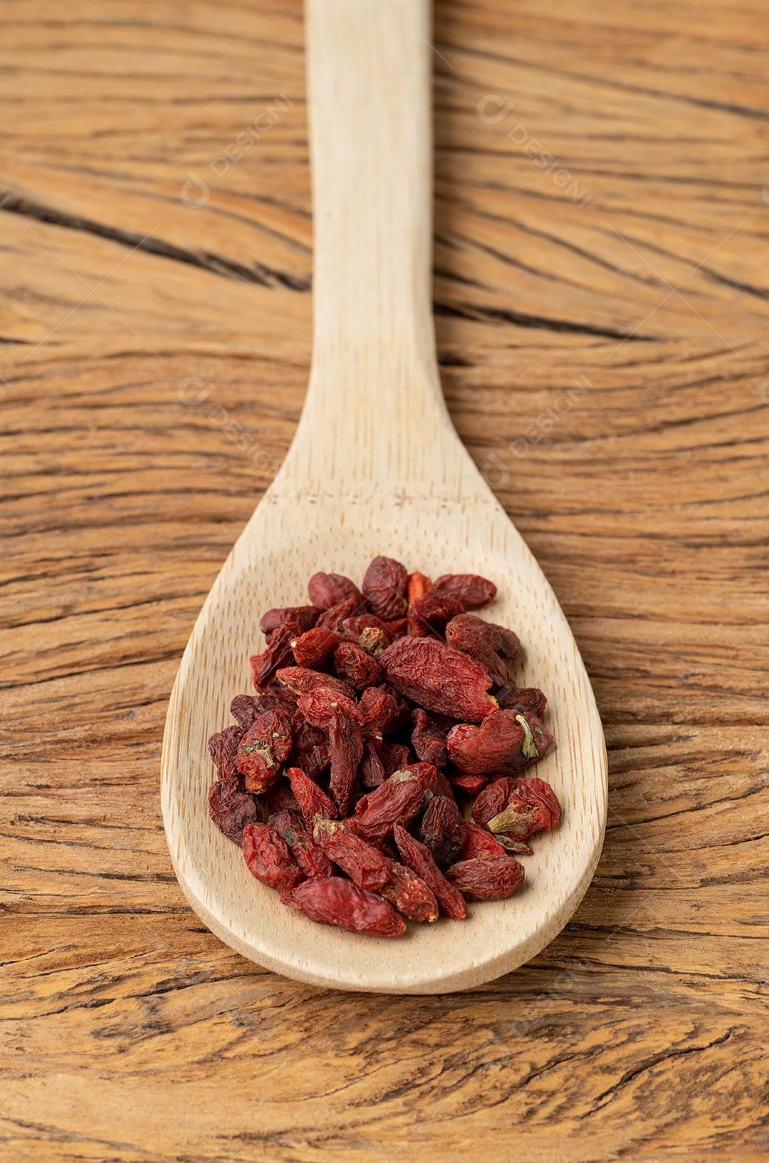 Goji berry em uma colher sobre a mesa de madeira