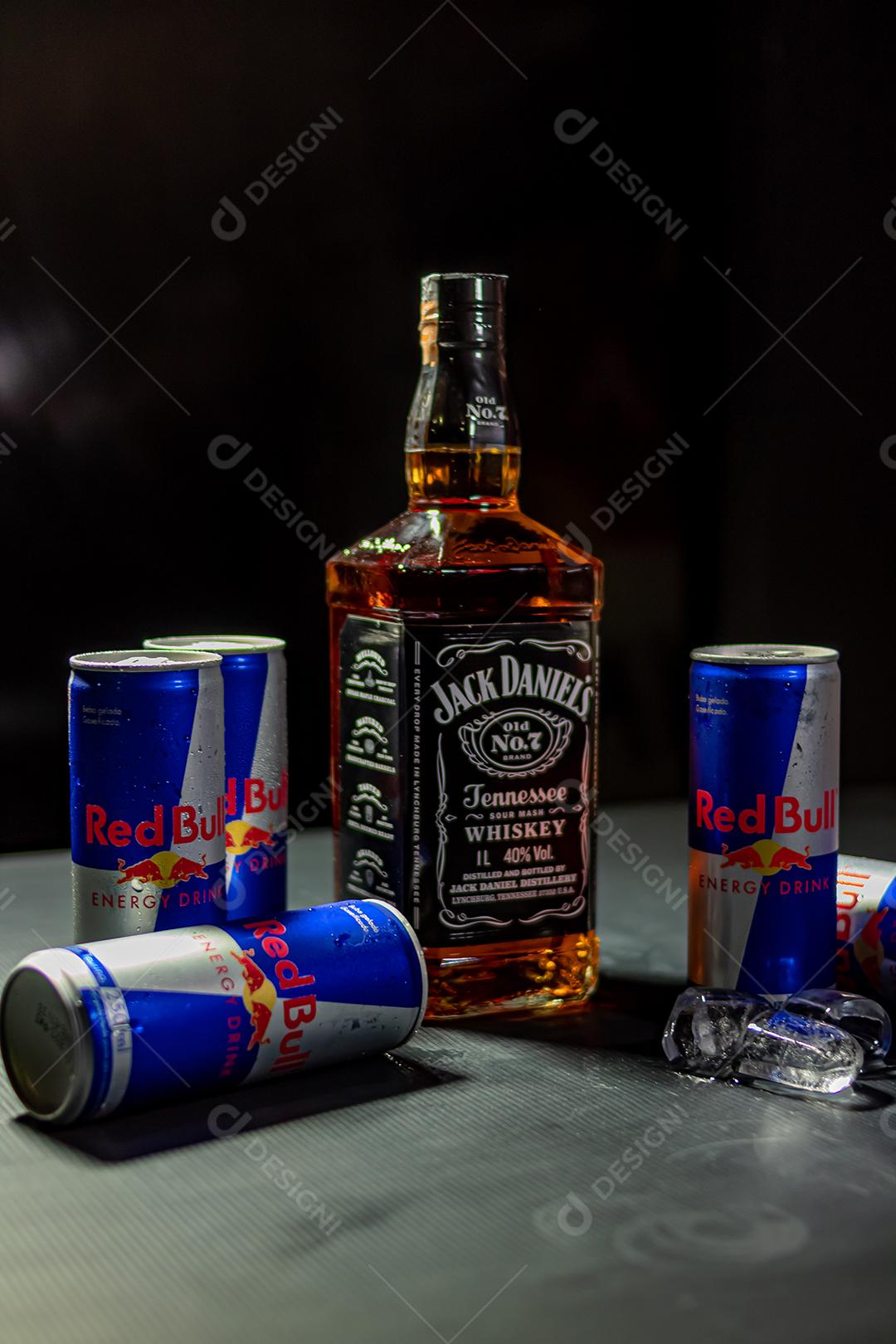 Garrafa de Uísque Jack Daniels com energetico red Bul bebida sobre fundo preto