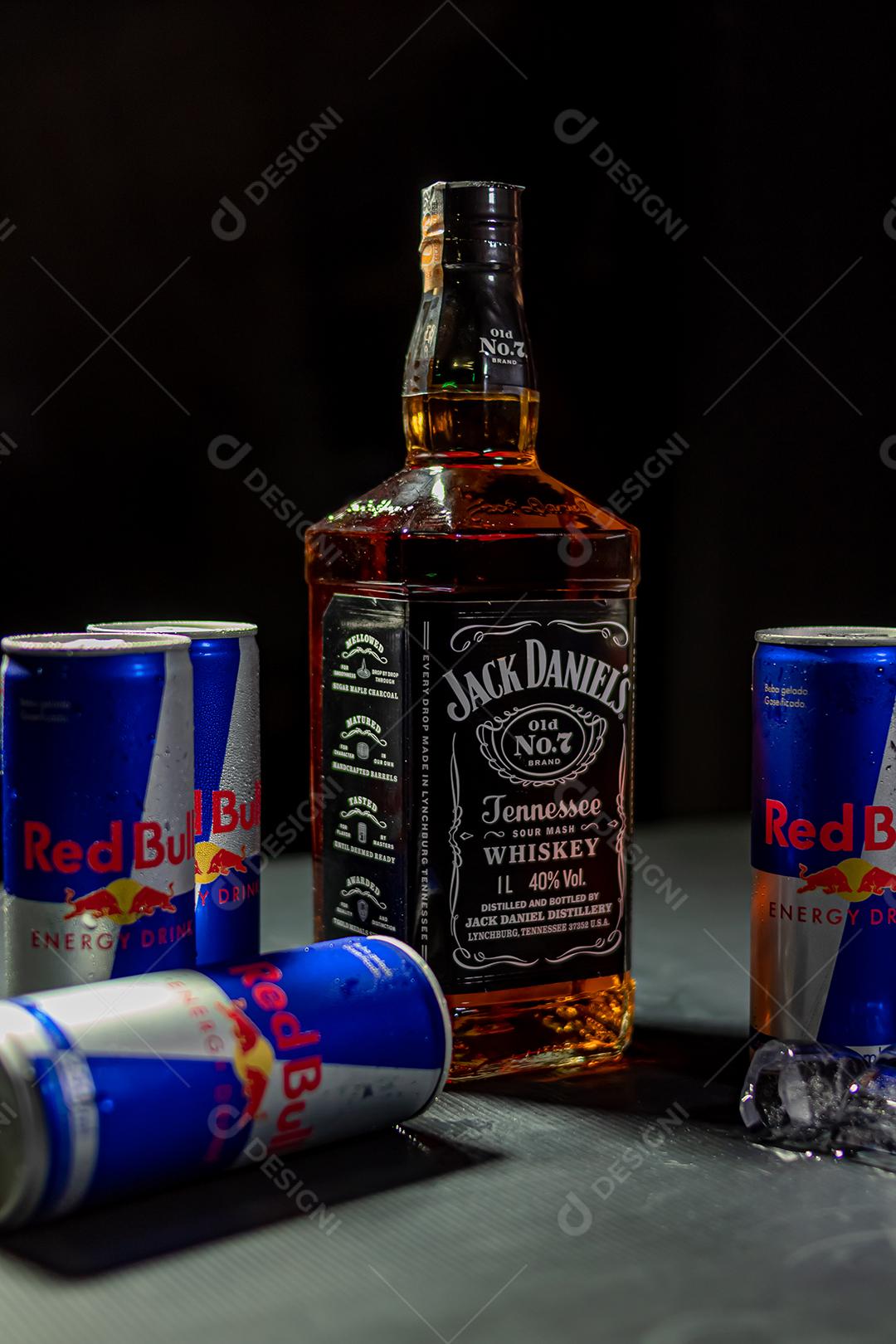 Garrafa de Uísque Jack Daniels com energetico red Bul bebida sobre fundo preto