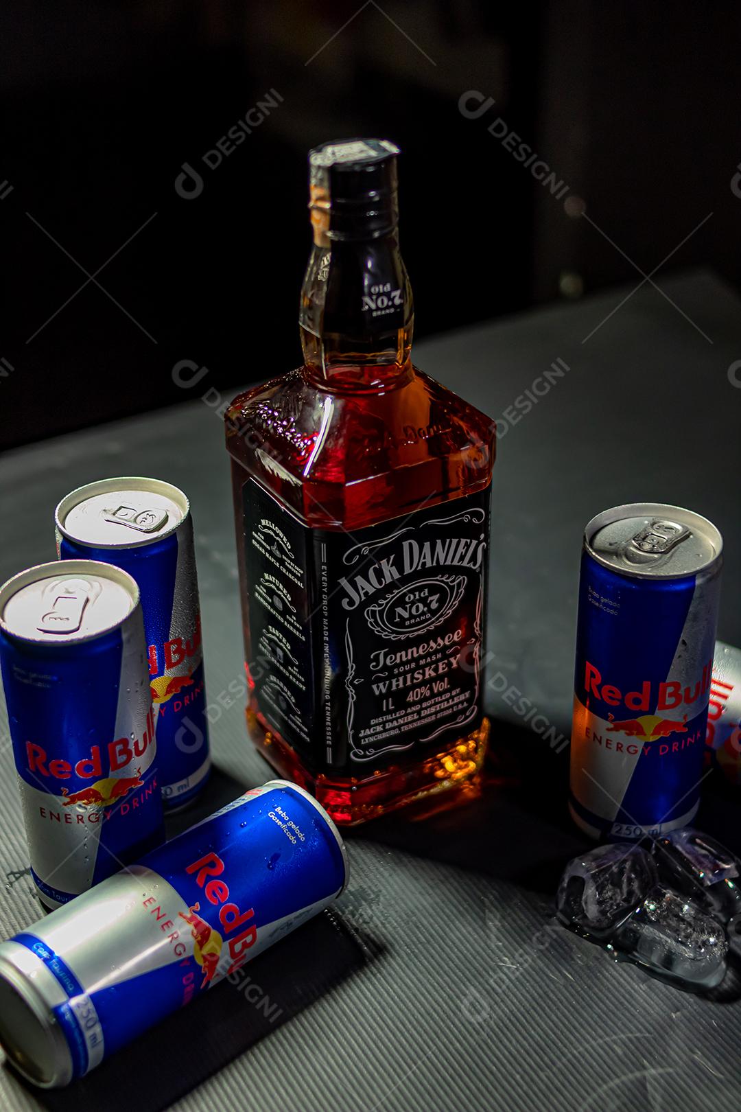 Garrafa de Uísque Jack Daniels com energetico red Bul bebida sobre fundo preto