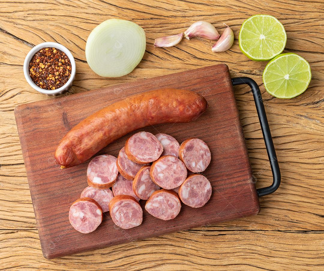 Calabrese pork sausage with slices over wooden board with season
