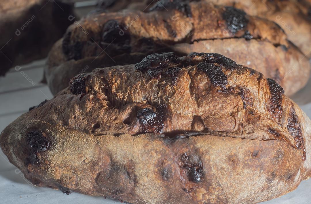 Pão francês de chocolate, pão de cacau assado com raspas de laranja e colocados juntos em uma prateleira.