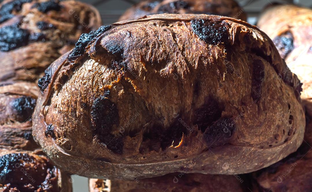 Pão francês de chocolate, pão de cacau assado com raspas de laranja e colocados juntos em uma prateleira.