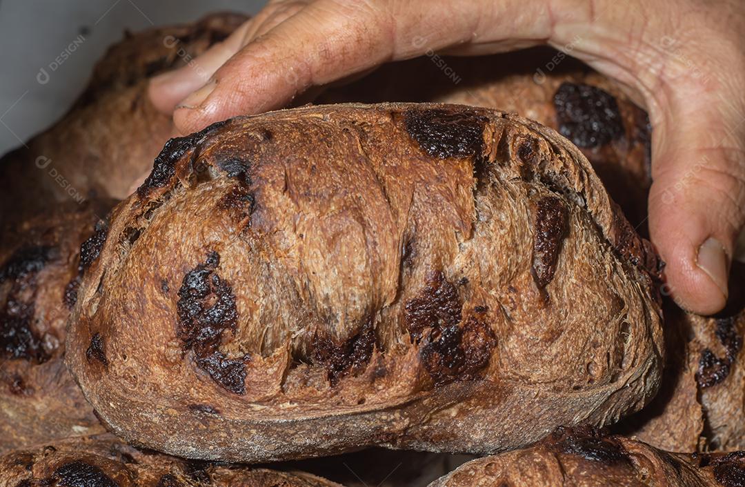 Pão francês de chocolate, pão de cacau assado com raspas de laranja e colocados juntos em uma prateleira.