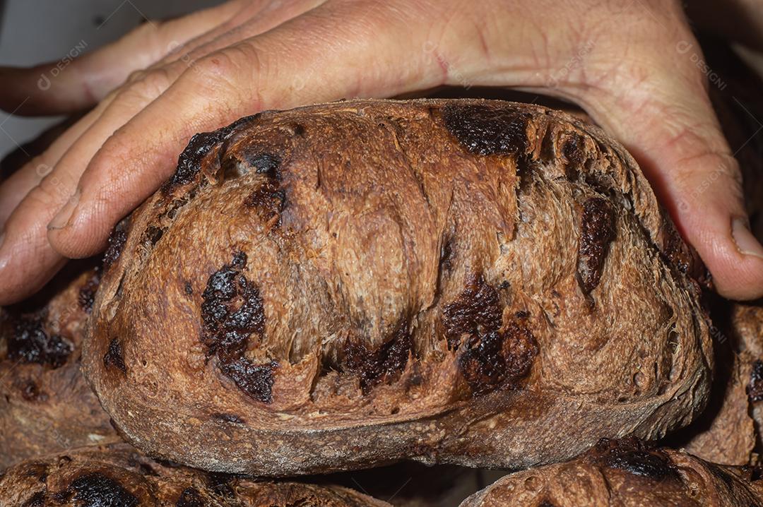 Pão francês de chocolate, pão de cacau assado com raspas de laranja e colocados juntos em uma prateleira.