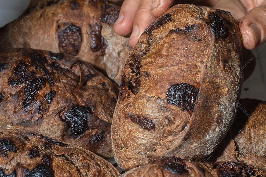 Pão francês de chocolate, pão de cacau assado com raspas de laranja e colocados juntos em uma prateleira.