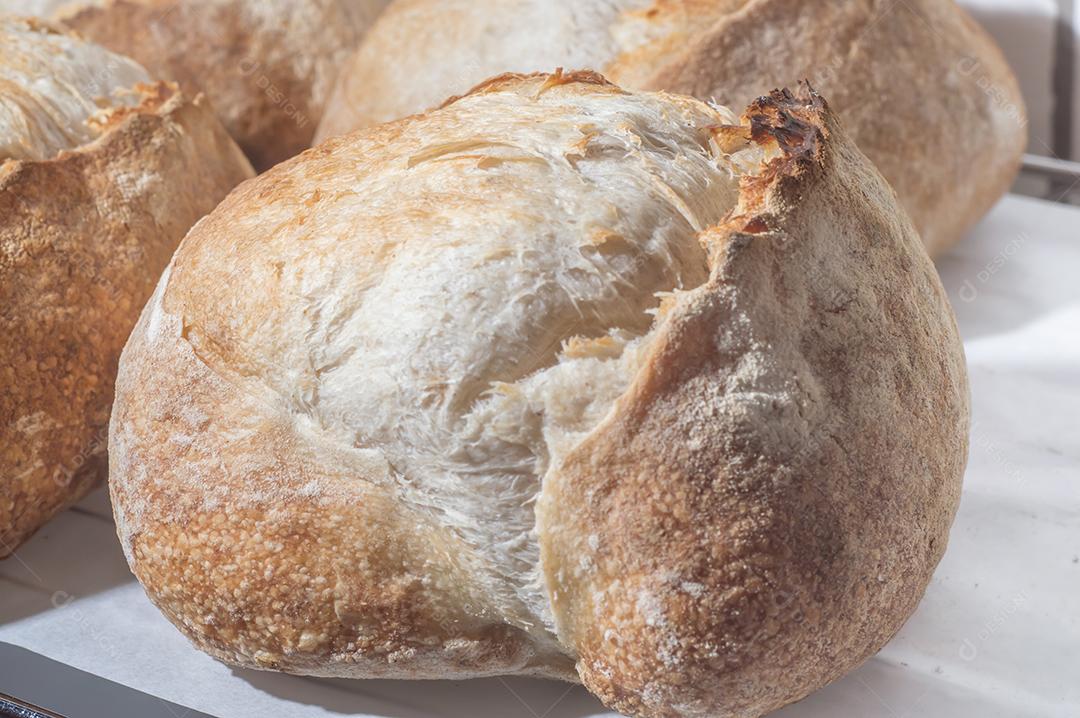 Pão italiano tradicional em uma prateleira com luz natural, pão artesanal.