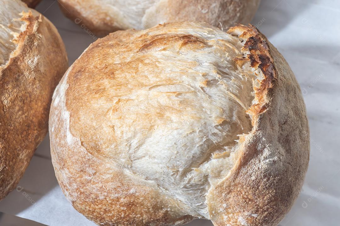 Pão italiano tradicional em uma prateleira com luz natural, pão artesanal.