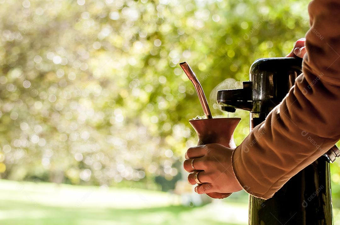 Mão segurando e servindo Mate de chimarrão, chá tropical da américa do sul