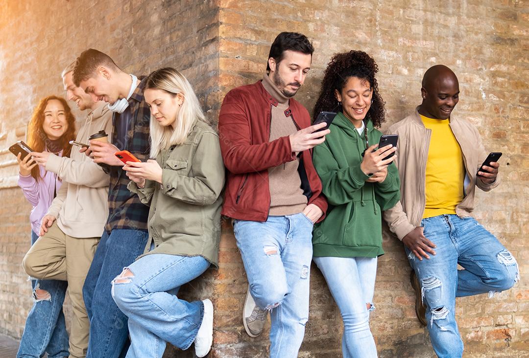 Grupo de amigos multirraciais usando smartphones para compartilhar conteúdo nas redes sociais