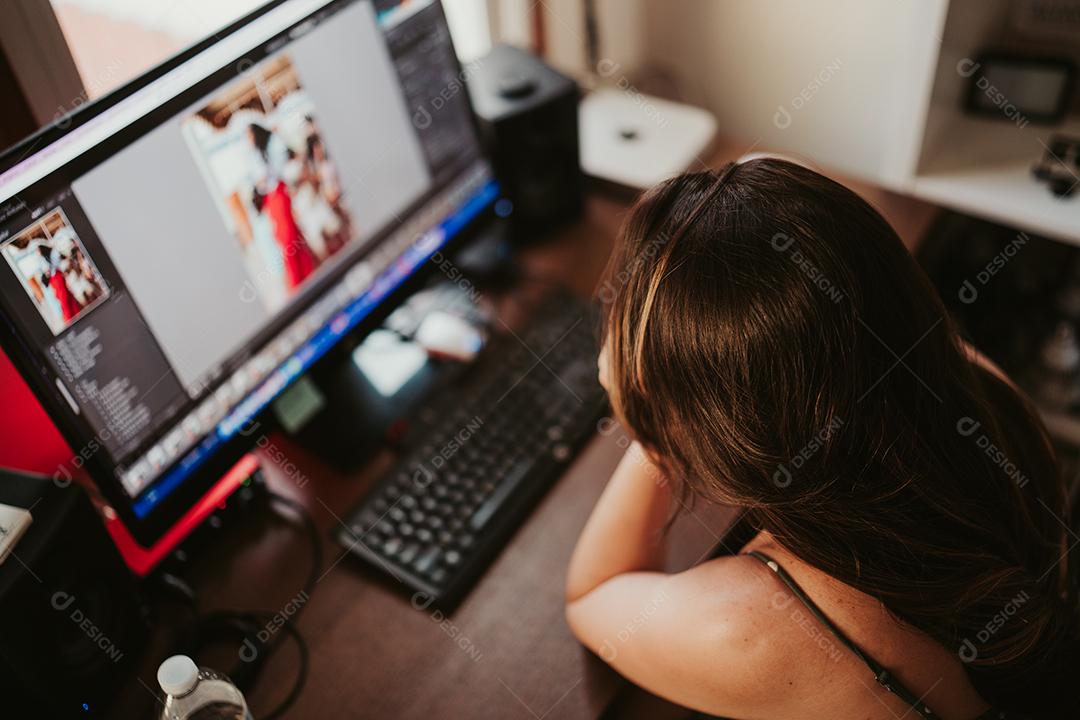 Mulher sorrindo em frente ao computador trabalhando em casa