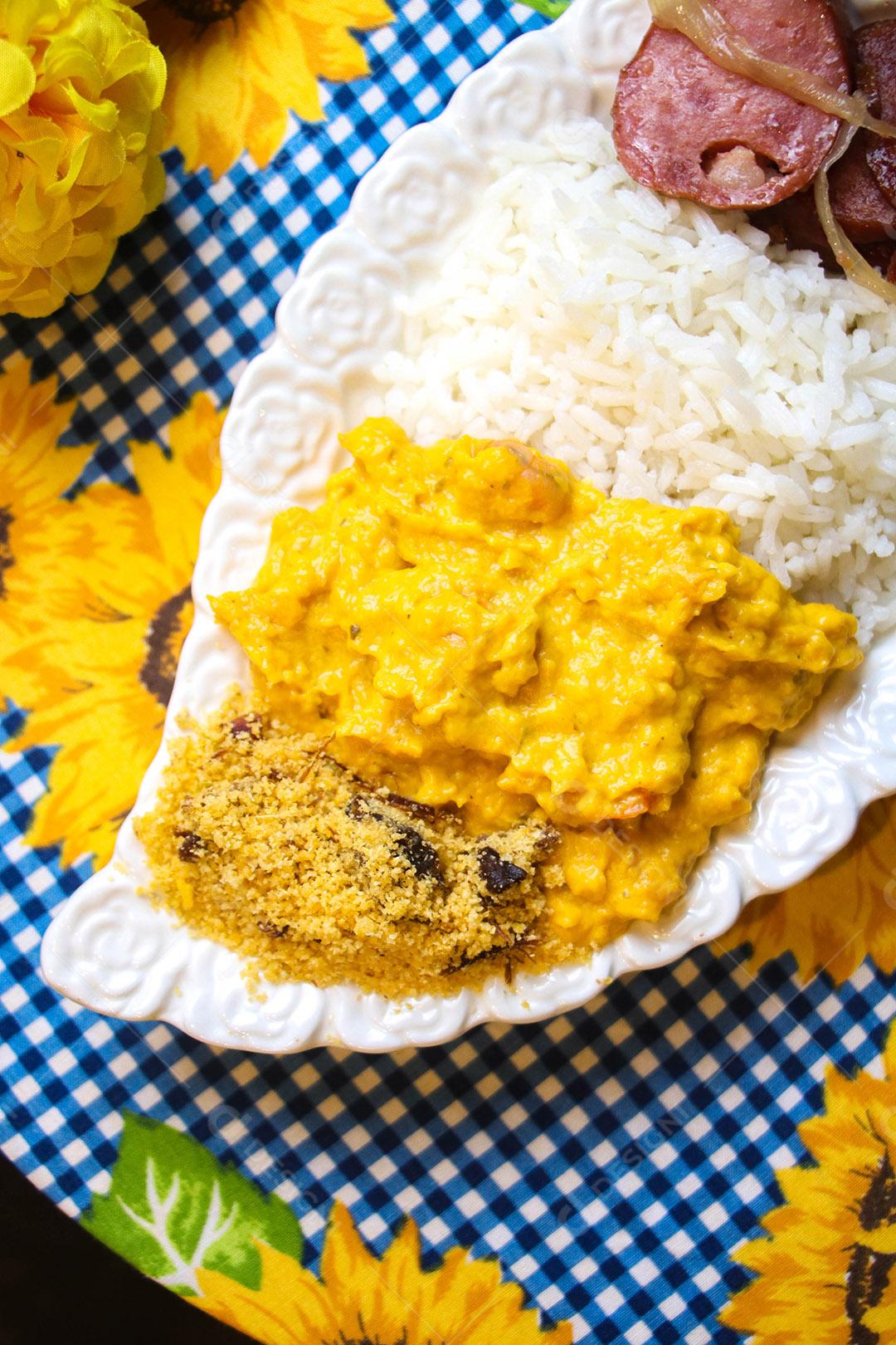 Prato de comida sobre uma mesa farofa strogonoff arroz calabresa linguiça