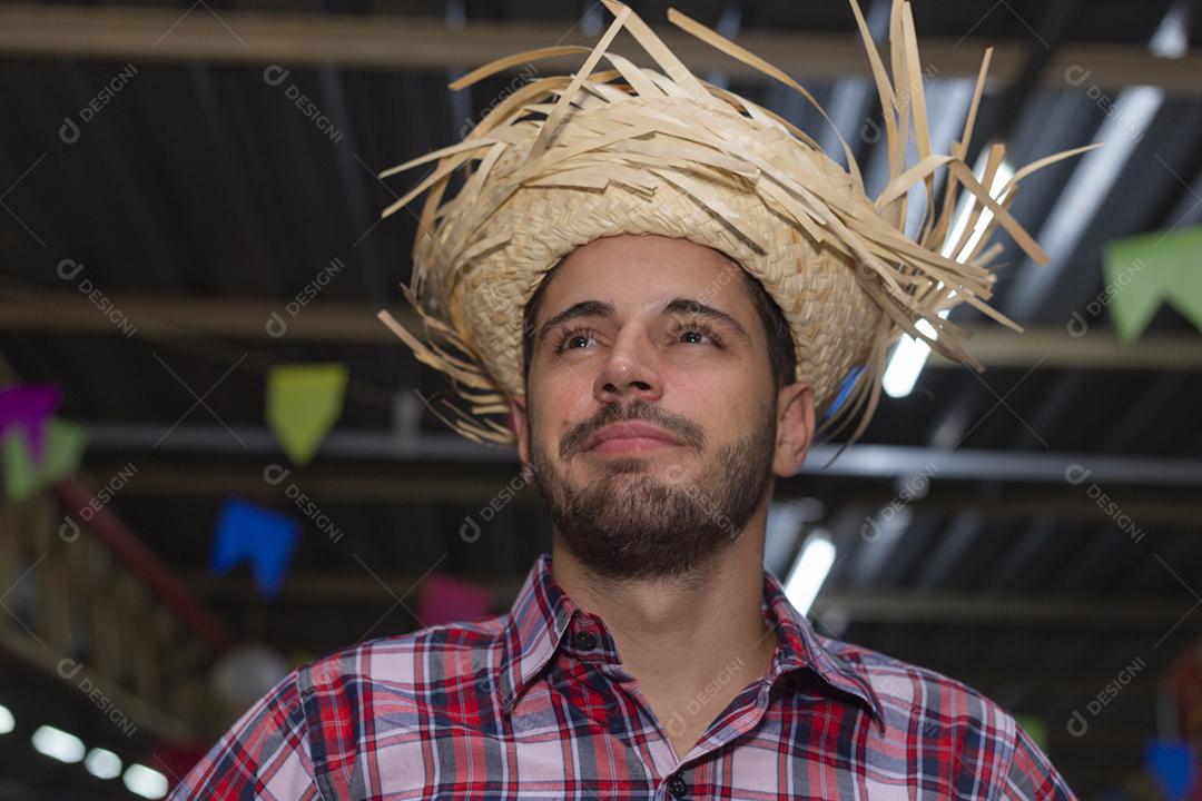 Homem bonito com roupas típicas da festa junina sorrindo