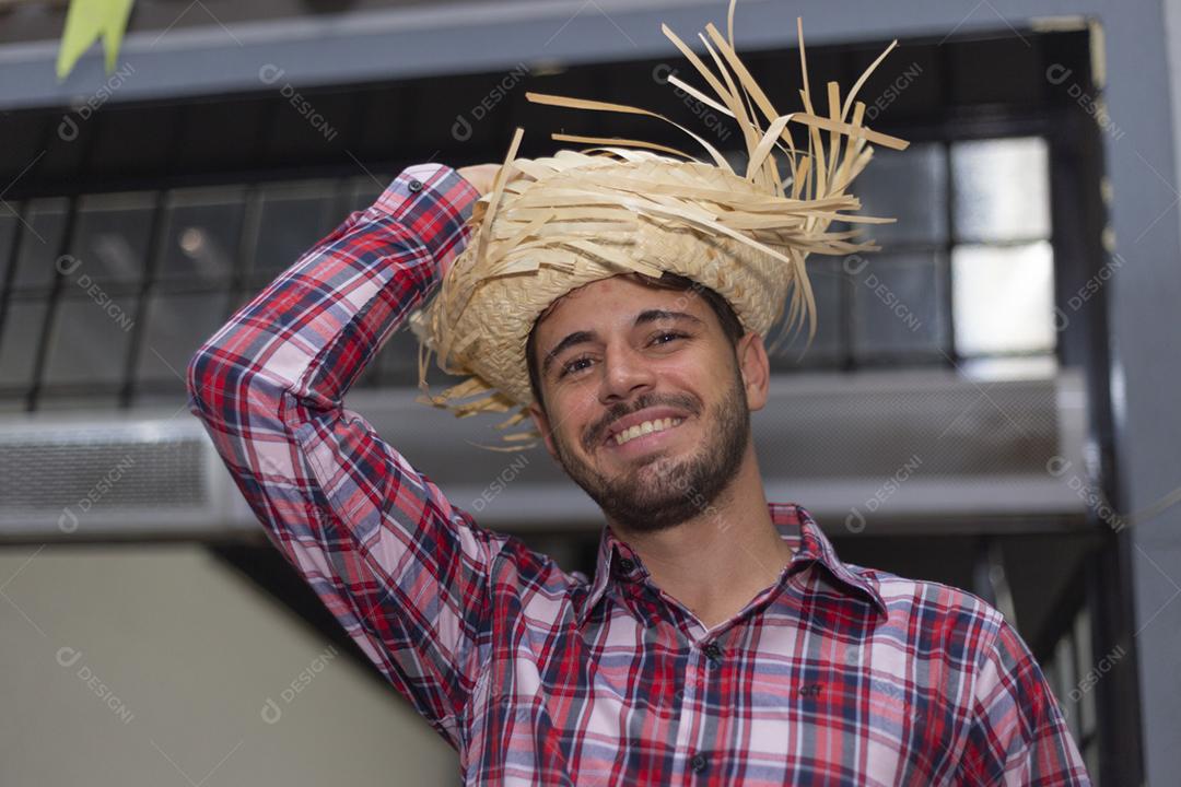 Homem bonito com roupas típicas da festa junina sorrindo