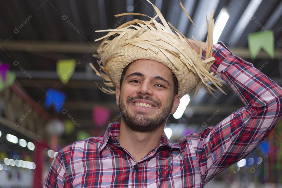 Homem bonito com roupas típicas da festa junina sorrindo