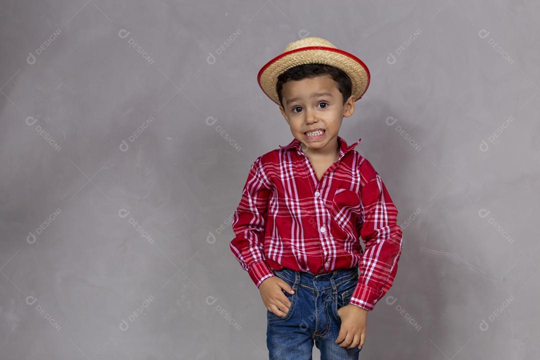 menino bonitinho vestindo roupas típicas para Festa Junina