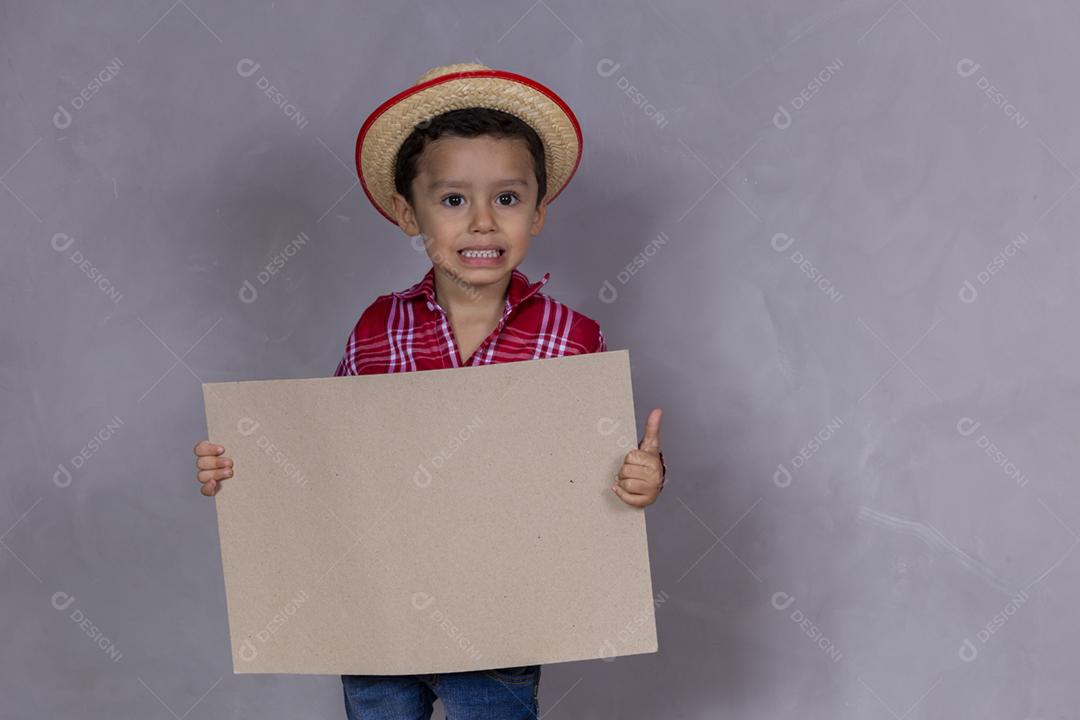 homenzinho com roupa de festa junina segurando um cartão em branco para texto