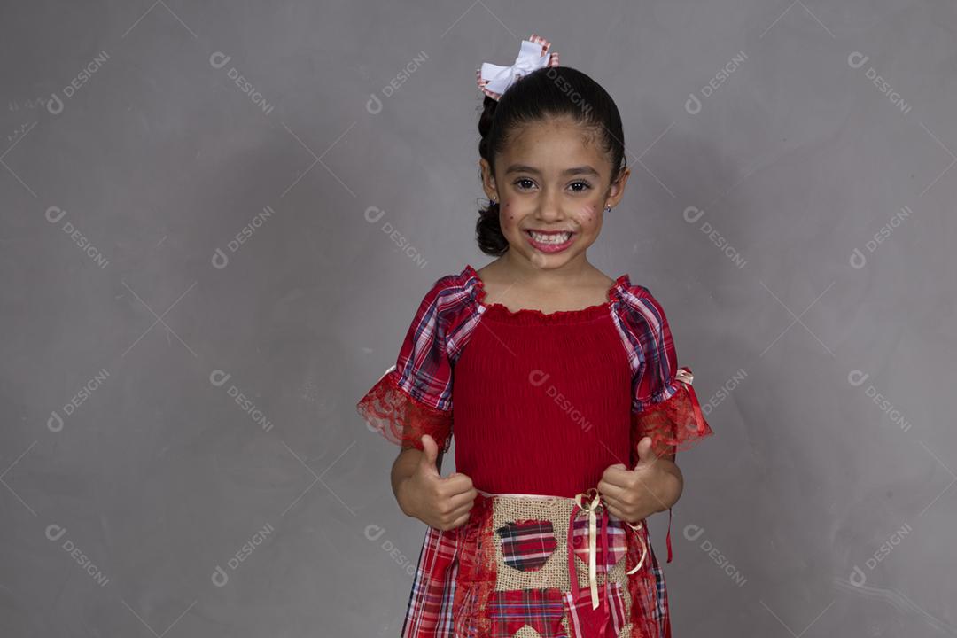 Menina vestindo roupas tradicionais para o Festa Junina