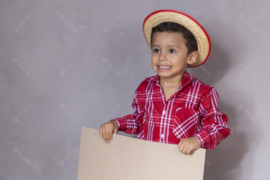 homenzinho com roupa de festa junina segurando um cartão em branco para texto