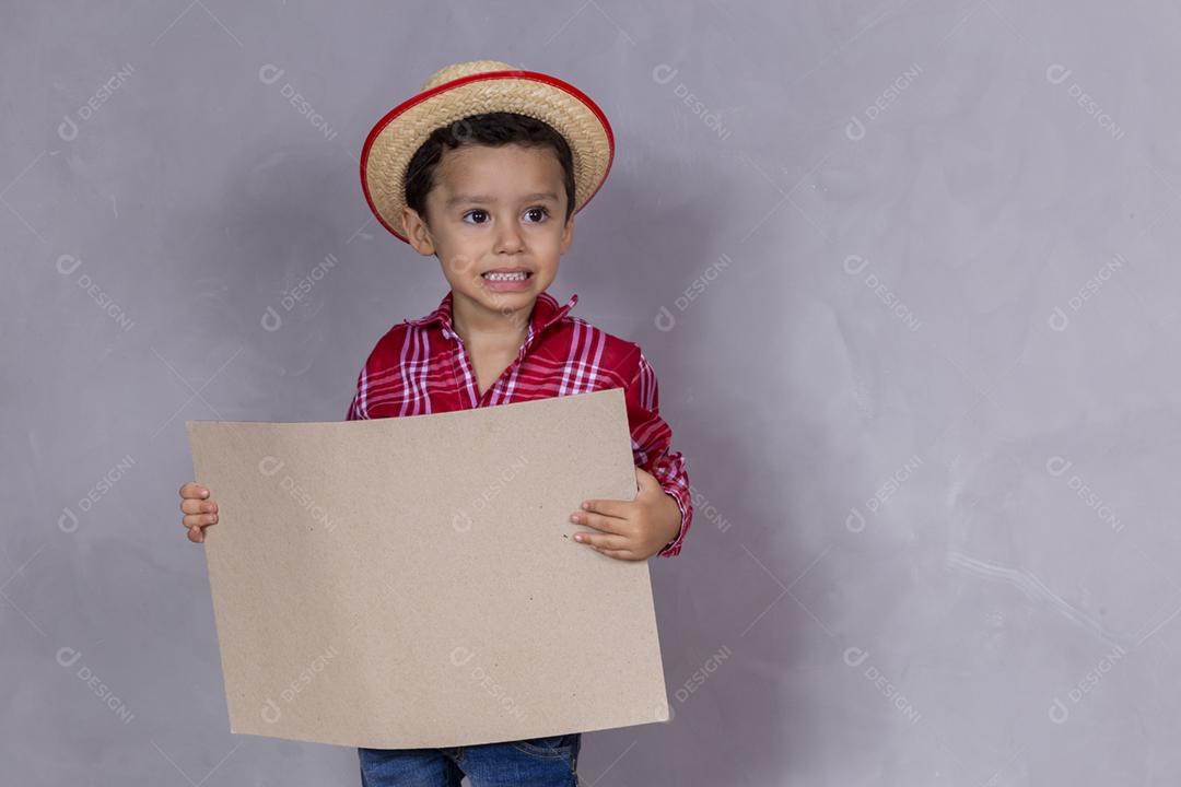 homenzinho com roupa de festa junina segurando um cartão em branco para texto
