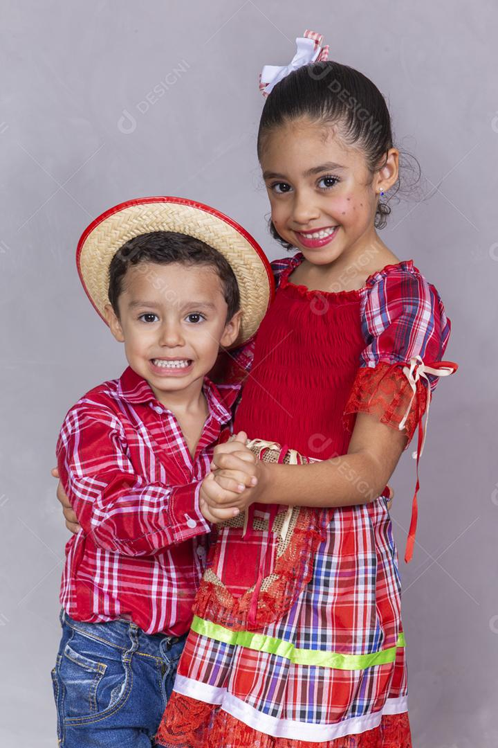 casal de irmãos vestindo roupas tradicionais para a Festa Junina