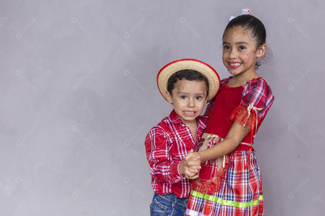 casal de irmãos vestindo roupas tradicionais para a Festa Junina