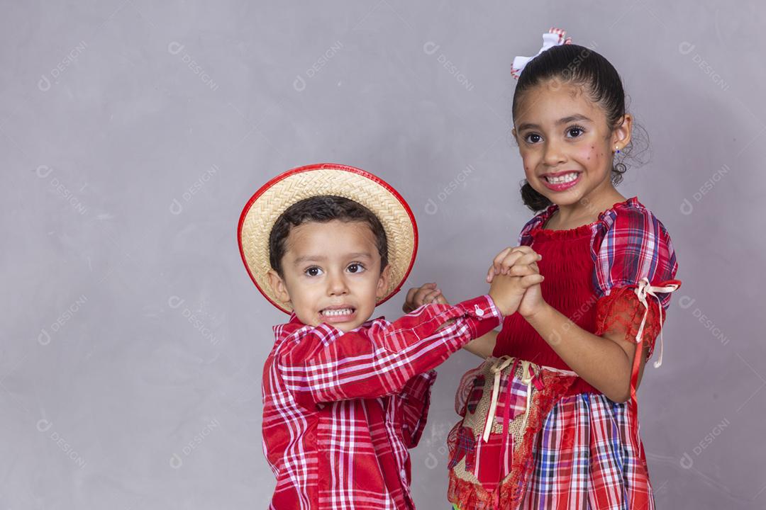 casal de irmãos vestindo roupas tradicionais para a Festa Junina