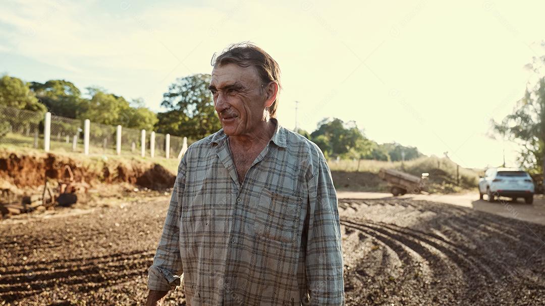 Agricultor latino andando pelo pátio de café orgulhoso de colher co