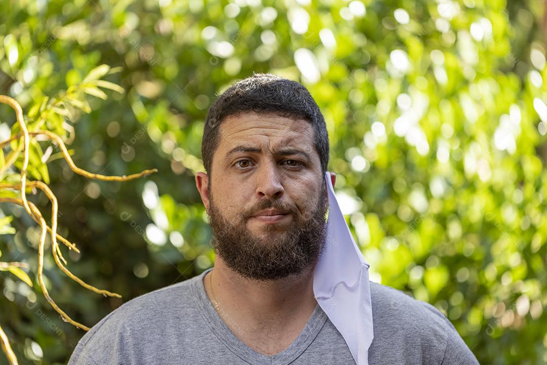 homem com mascara de proteção retirada do rosto