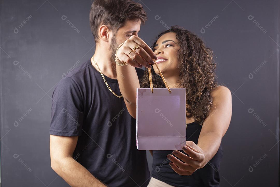 Lindo casal elegante de Jovens segurando saco de presente