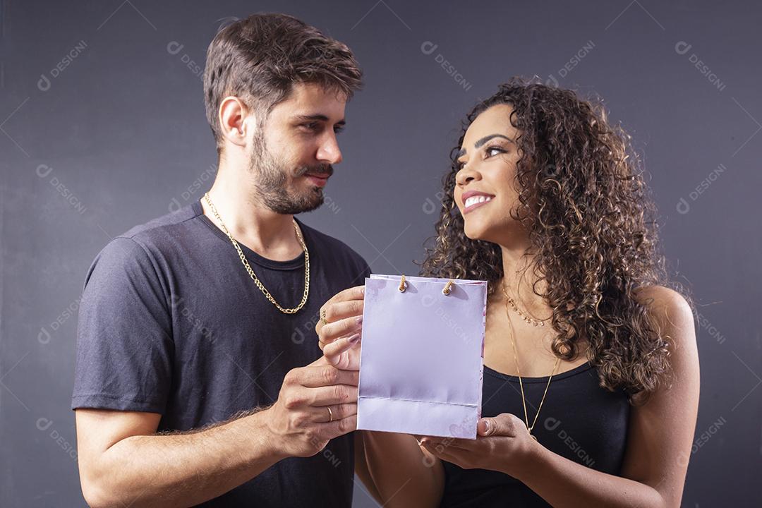Lindo casal elegante de Jovens segurando saco de presente