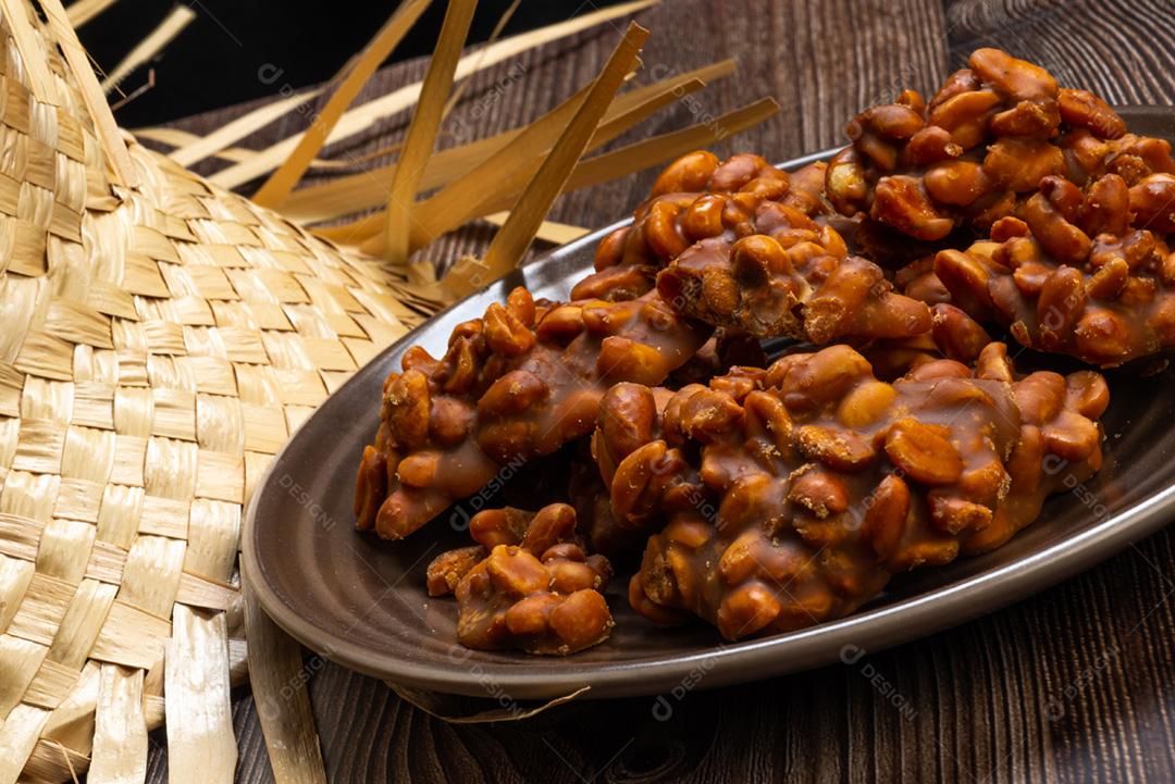 Doce de amendoim servido em prata marrom com chapéu de palha em madeira