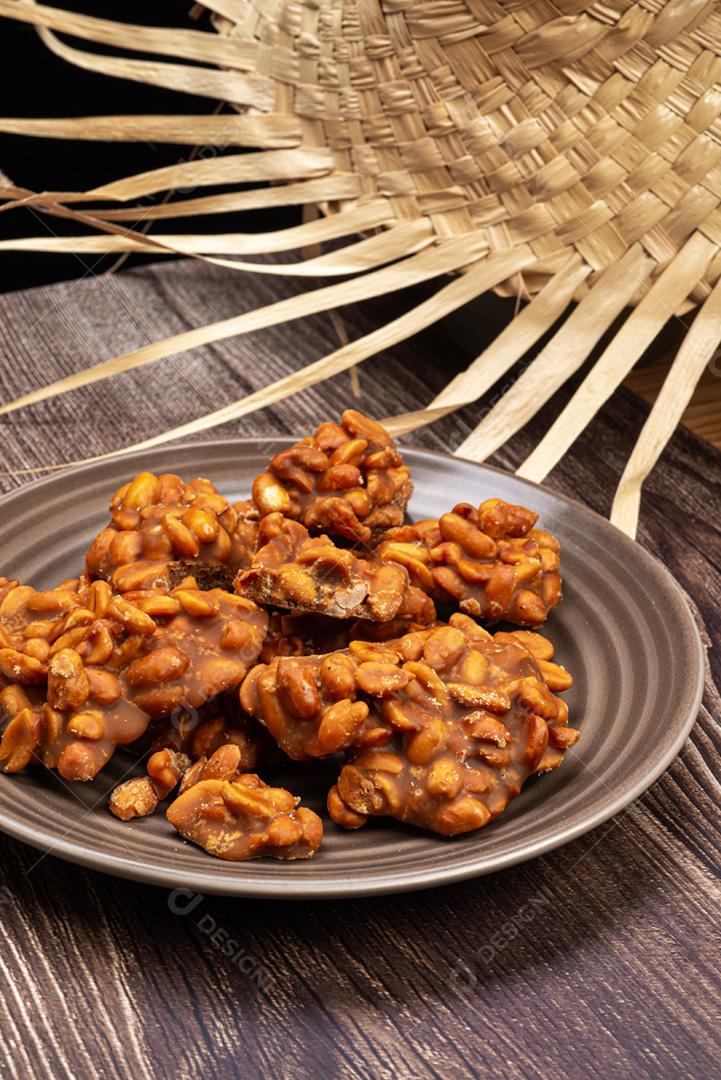 Doce de amendoim servido em prata marrom com chapéu de palha em madeira