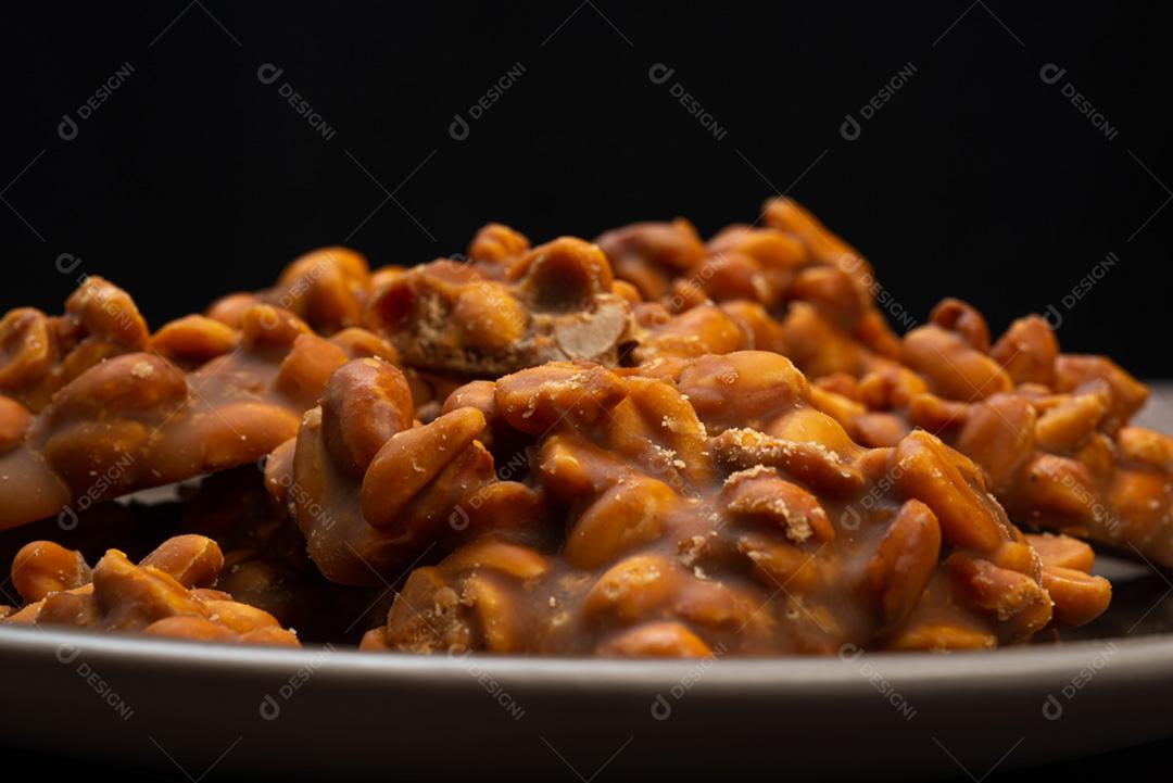 Doce de amendoim servido em prata marrom com chapéu de palha em madeira