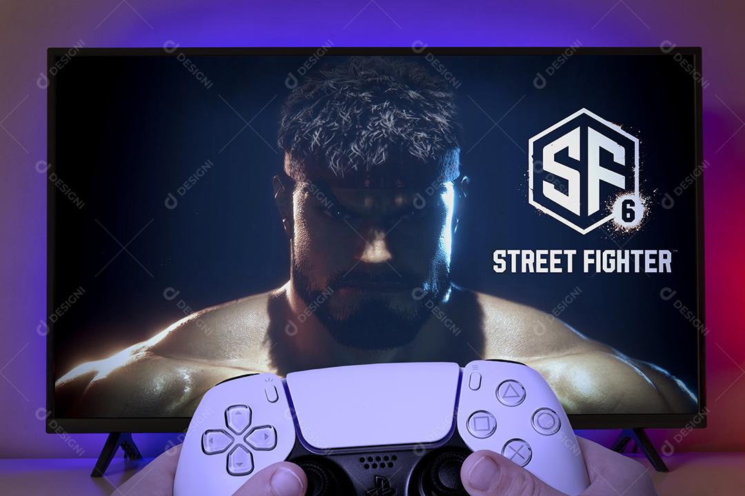 Garoto segurando o controle do Playstation 5 com o logotipo do Street Fighter 6 na tela da TV, 9 de junho de 2022, São Paulo, Brasil.