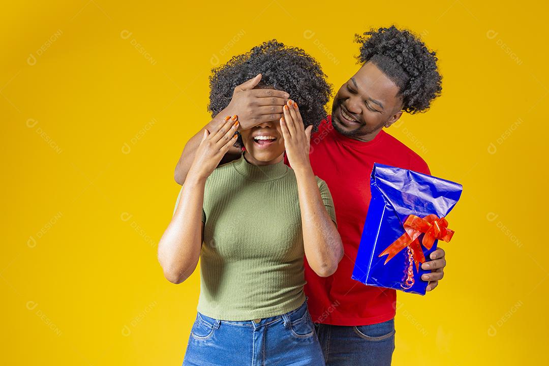 Homem Afro sorridente fazendo surpresa para sua namorada