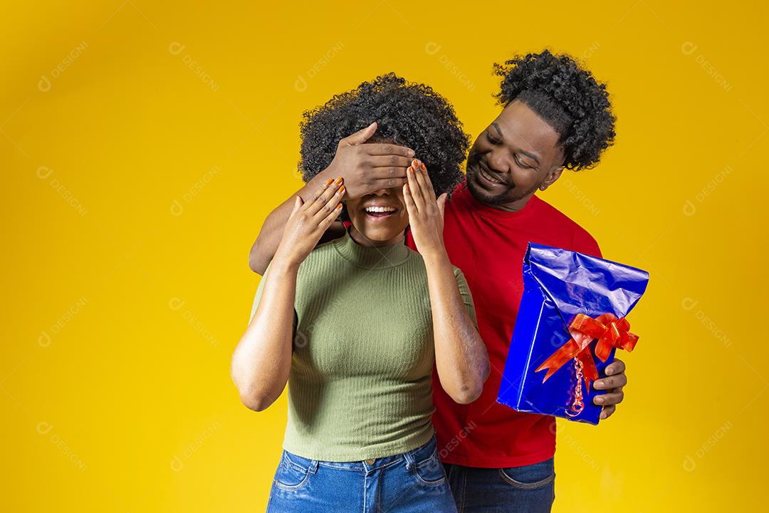 Homem Afro sorridente fazendo surpresa para sua namorada