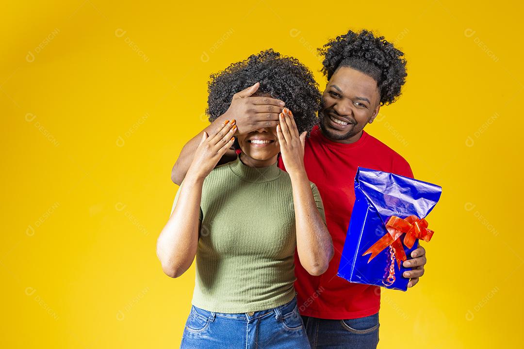 Homem Afro sorridente fazendo surpresa para sua namorada