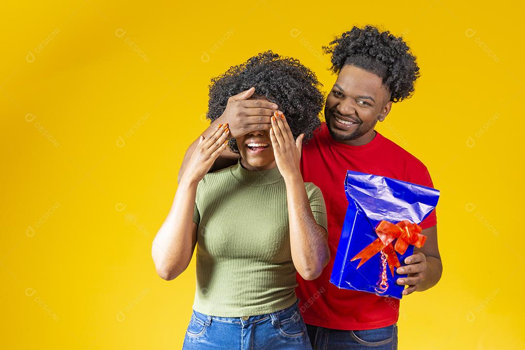 Homem Afro sorridente fazendo surpresa para sua namorada