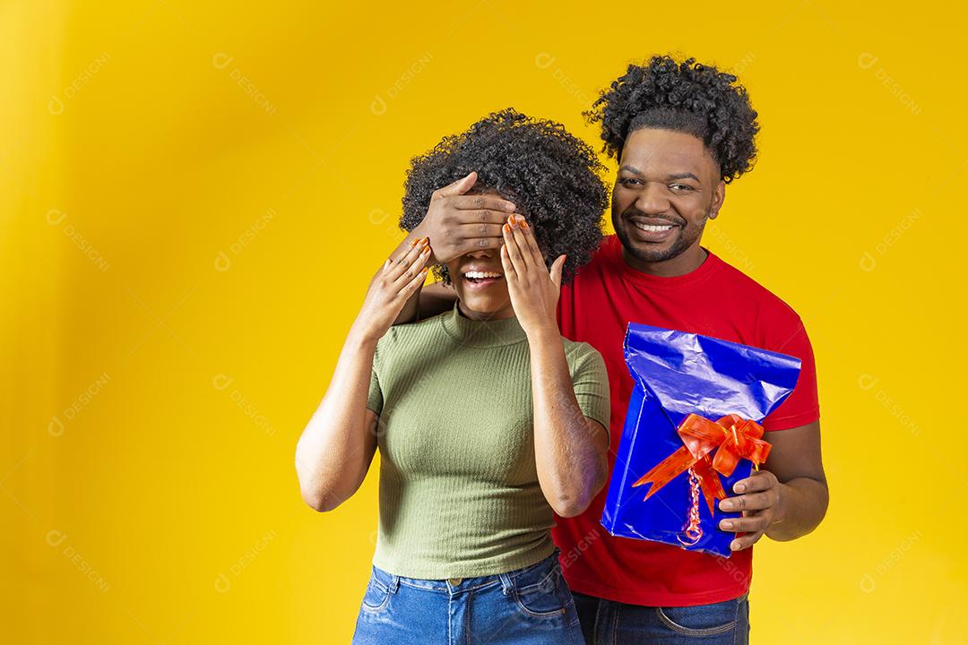 Homem Afro sorridente fazendo surpresa para sua namorada