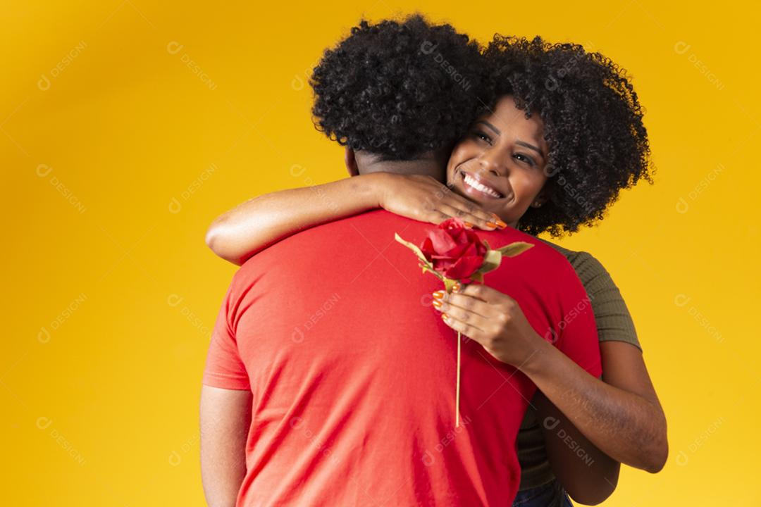 black couple embracing on yellow background and woman holding a flower