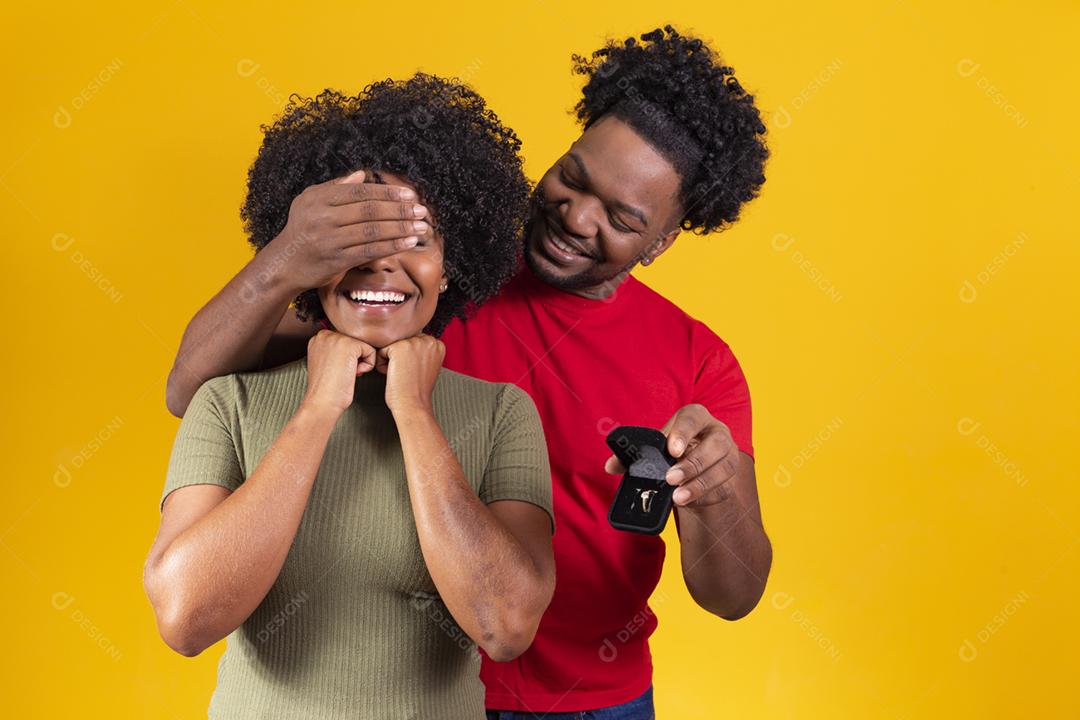 Retrato de um jovem namorado segurando uma pequena caixa com joias isola