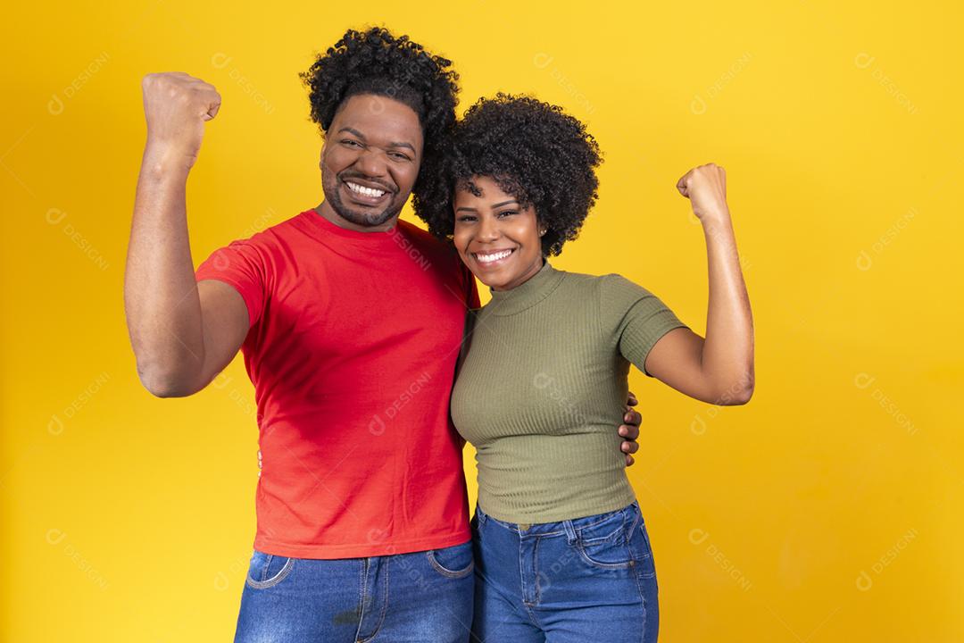 Grande vitória. Feliz casal afro regozijando-se com o sucesso, comemorando o vencedor