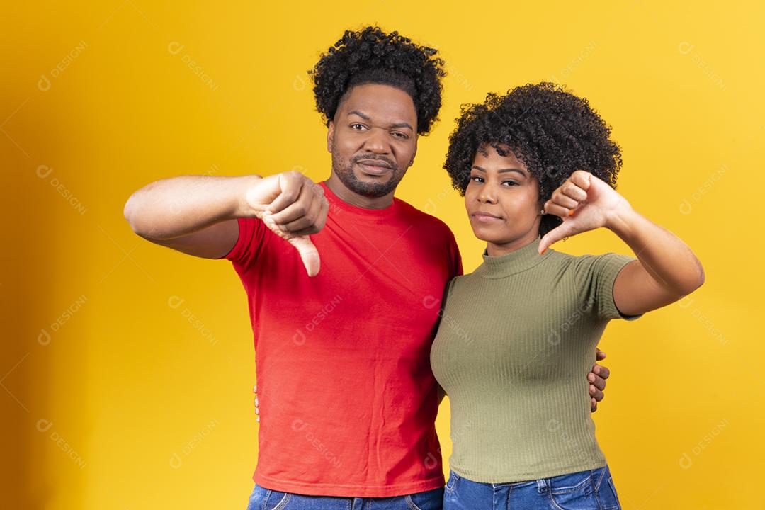 Casal negro com o polegar para baixo fazendo sinal negativo