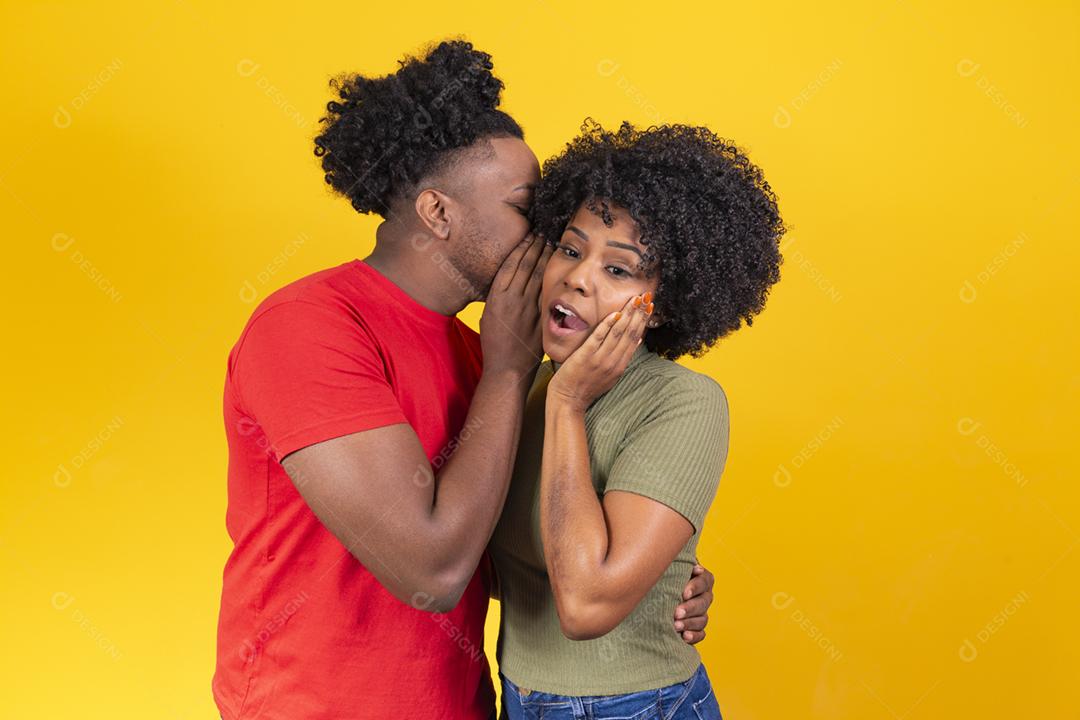 namorado contando um segredo no ouvido da namorada que está chocada