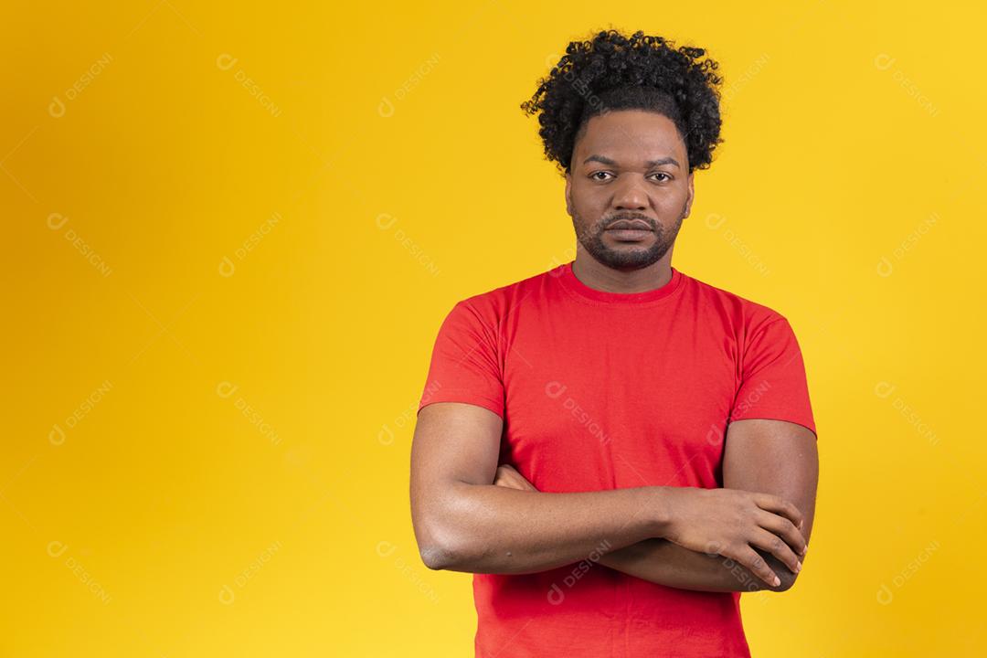Homem afro com braços cruzados, olhando para a câmera séria