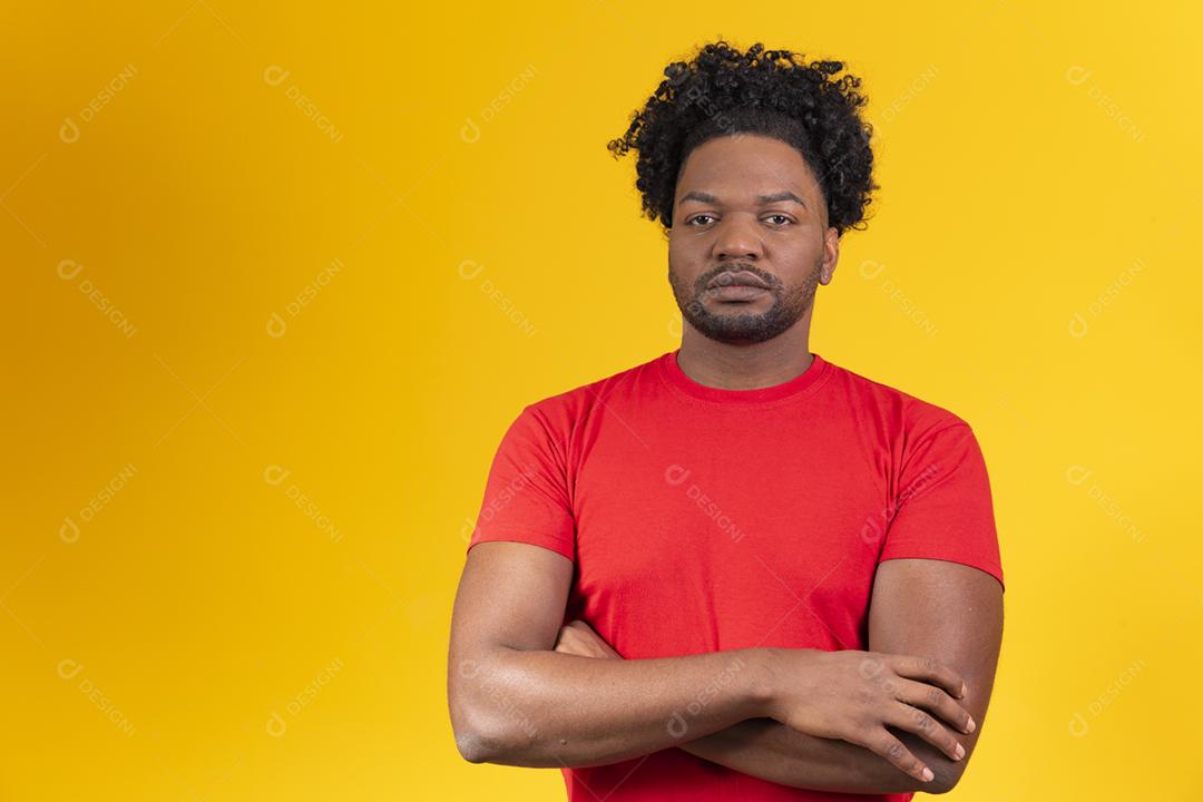 Homem afro com braços cruzados, olhando para a câmera séria