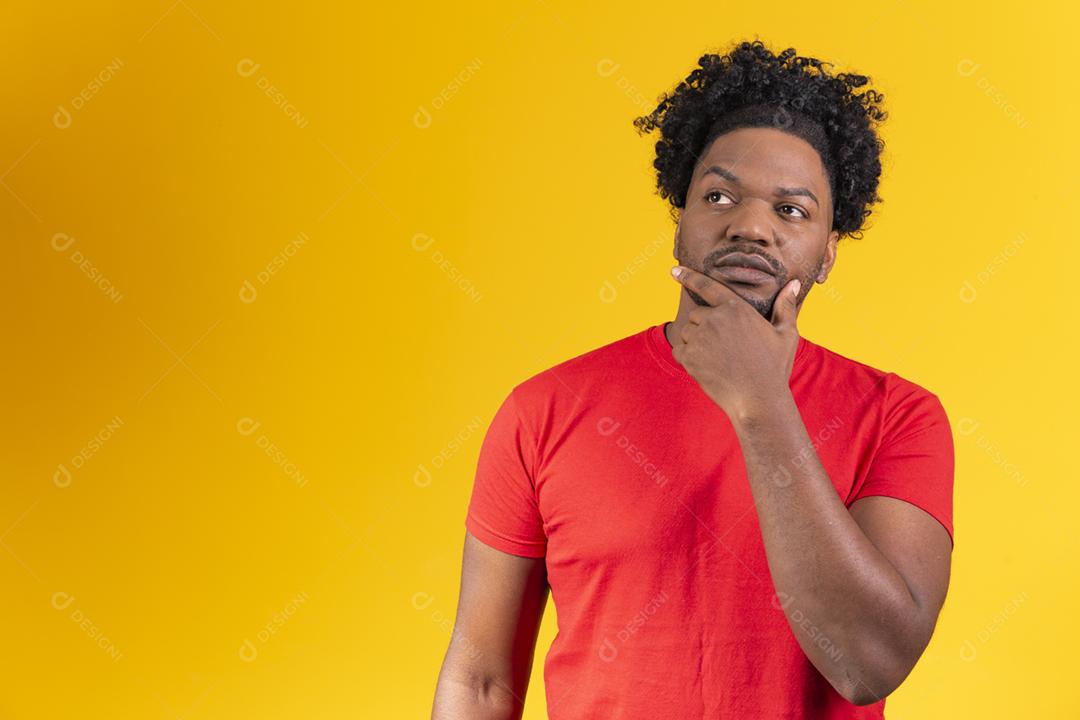 Homem afro com óculos em fundo amarelo sorrindo com a mao no oculos